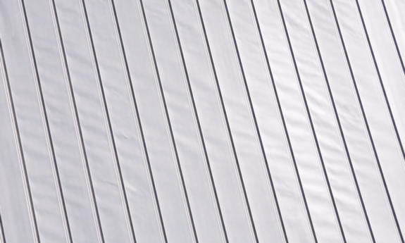 An example of oil canning, or visible waviness, on a gray metal roof.