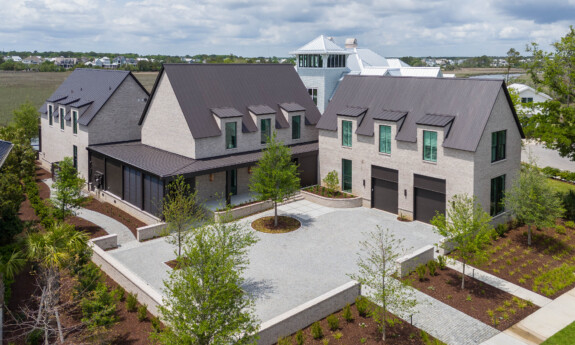 A wide view image of a neutral home with a antique bronze metal roof.