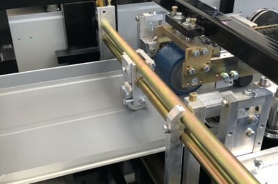 A close up of rive and rib rollers on a rollformer.